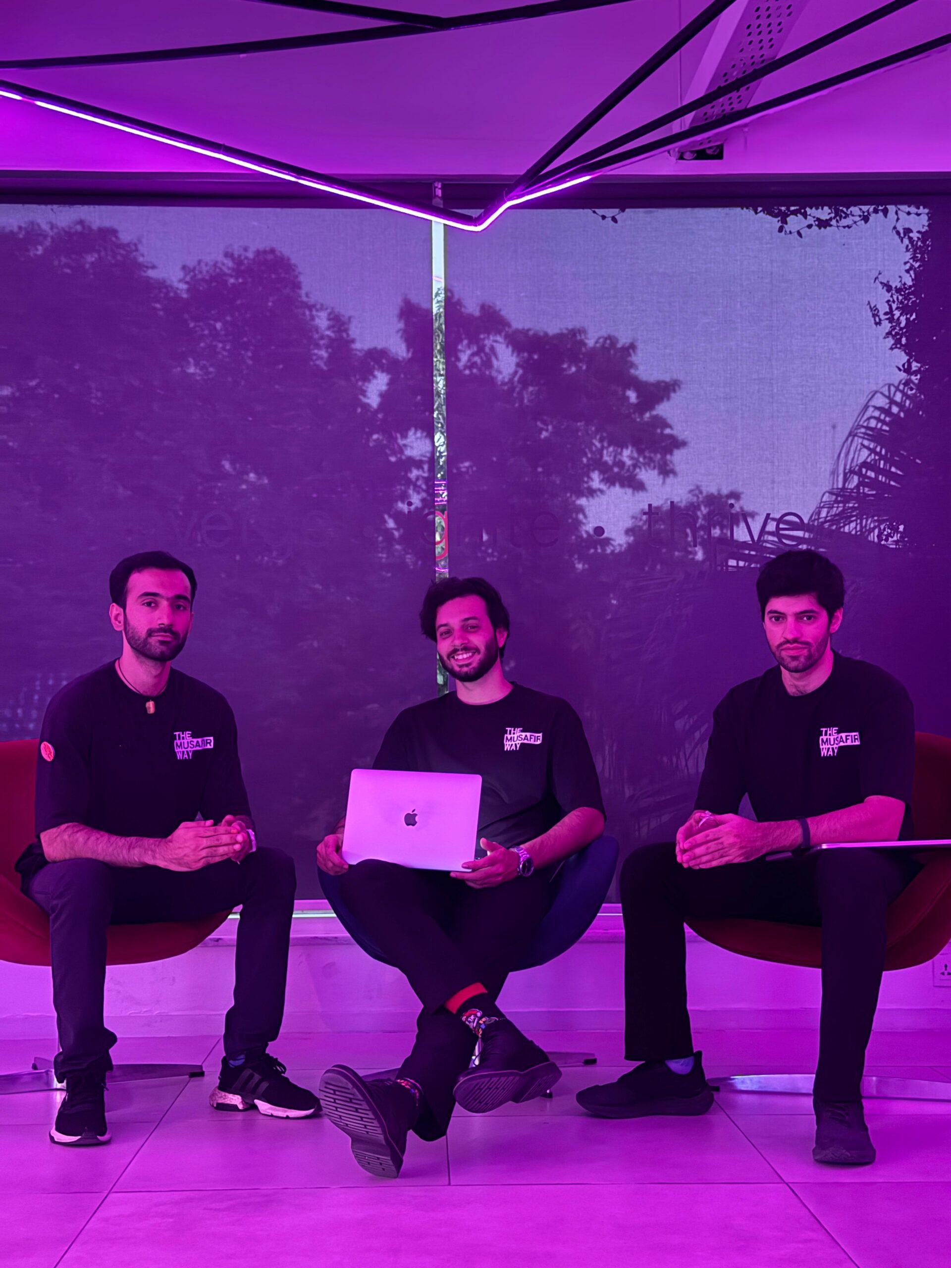 Founders in a purple-lit workspace with a laptop between them